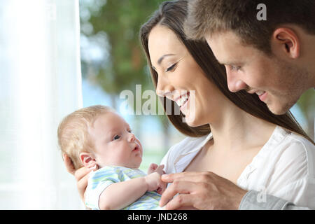 Orgogliosi genitori holding e giocare con il loro bambino a casa Foto Stock