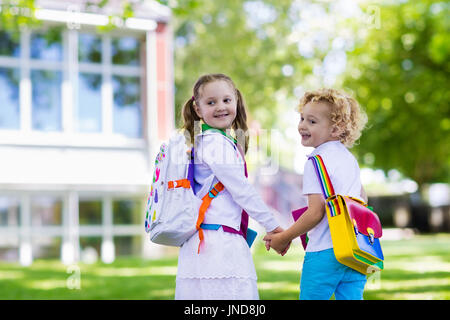 I bambini di tornare a scuola. Inizio del nuovo anno scolastico dopo le vacanze estive. Un ragazzo e una ragazza con zaino e libri sul primo giorno di scuola. Inizio di CLA Foto Stock