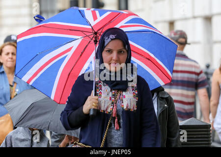 Whitehall. Westminster. Londra, Regno Unito. Il 30 luglio, 2017. I turisti riparo dalla pioggia in Whitehall, Westminster. Credito: Dinendra Haria/Alamy Live News Foto Stock