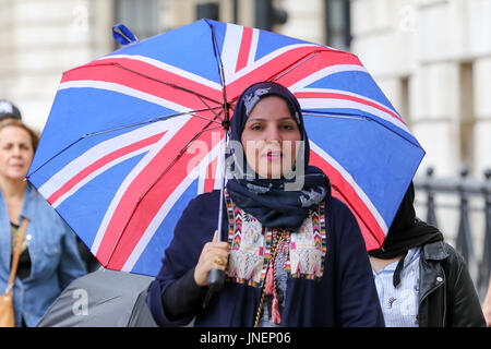 Whitehall. Westminster. Londra, Regno Unito. Il 30 luglio, 2017. I turisti riparo dalla pioggia in Whitehall, Westminster. Credito: Dinendra Haria/Alamy Live News Foto Stock
