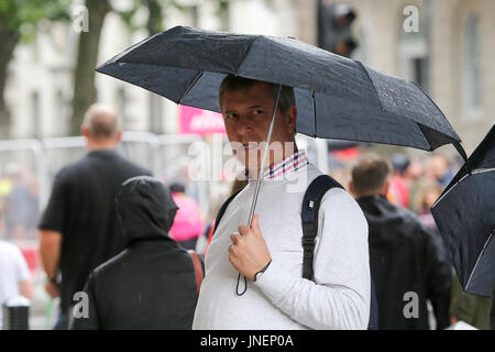Whitehall. Westminster. Londra, Regno Unito. Il 30 luglio, 2017. I turisti riparo dalla pioggia in Whitehall, Westminster. Credito: Dinendra Haria/Alamy Live News Foto Stock