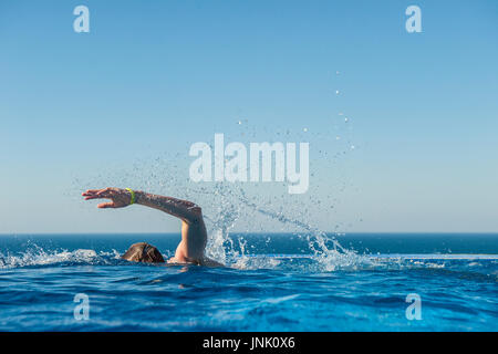 Un ragazzo adolescente treni in una piscina infinity Foto Stock
