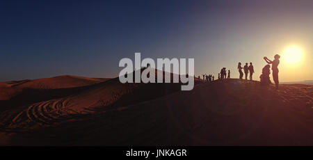 Dubai, Emirati Arabi Uniti - 4 gennaio 2015: il turista a godere il bellissimo tramonto vista sulle dune di sabbia nel deserto di Dubai. Foto Stock