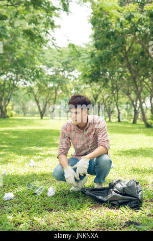 I volontari di prelevare i rifiuti in piccolo contenitore bag nel parco Foto Stock