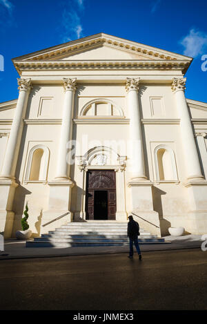 Uomo chiesa buio luce, vista posteriore di un uomo che emerge dall'ombra scura quando si avvicina ad una chiesa a Sassari, nel nord della Sardegna. Foto Stock