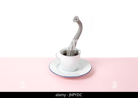 Una proboscide emergente da un design di piccole dimensioni tazza di caffè come se egli fosse nascosto. Il minimo divertente e stravagante design vita ancora fotografia Foto Stock