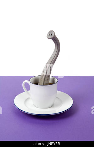 Una proboscide emergente da un design di piccole dimensioni tazza di caffè come se egli fosse nascosto. Il minimo divertente e stravagante design vita ancora fotografia Foto Stock