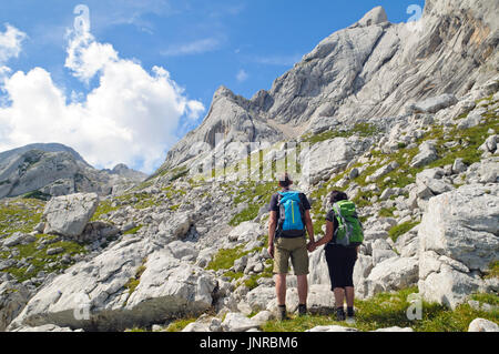 Felice coppia senior azienda ogni bracci e guardando le visualizzazioni in montagna. Foto Stock