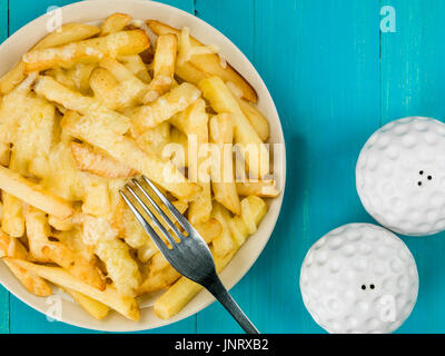 Ciotola di fritto e grigliate di formaggio chips contro un blu sullo sfondo di legno Foto Stock