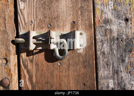 Un vecchio far scorrere il bullone o vite del tampone su un rustico porta stabile sulla storica proprietà Rowlee in arancione, NSW, Australia Foto Stock