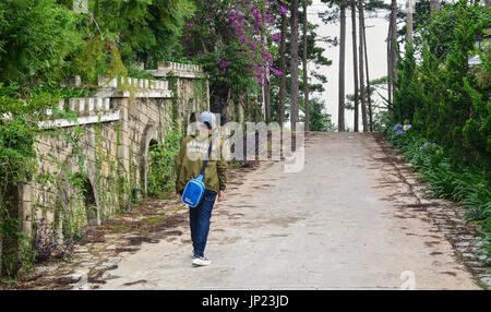 Dalat, Vietnam - il Lug 5, 2016. Un uomo a piedi su per la collina di Dalat, Vietnam. Da Lat nelle Highlands Centrali, è centrato intorno a un lago e campo da golf, e Foto Stock