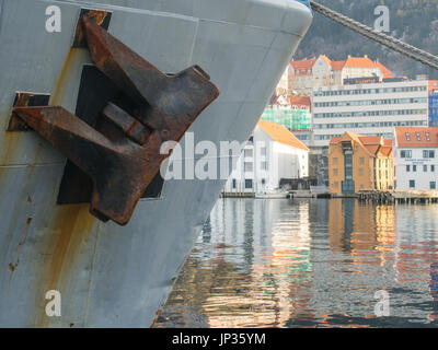 Bergen, Norvegia - 11 Febbraio 2017: ancoraggio di un mezzo navale con case norvegese sul bordo di un fiordo di Bergen in uno sfondo Foto Stock