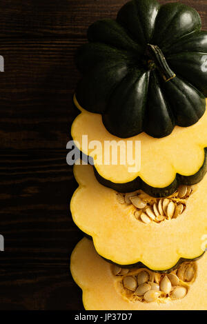 Fette di materie acorn squash su sfondo scuro Foto Stock