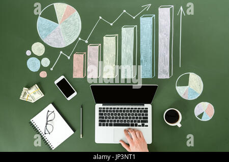 Vista superiore della persona di business utilizzando dispositivi digitali a workplace con grafici colorati, home concetto di ufficio Foto Stock