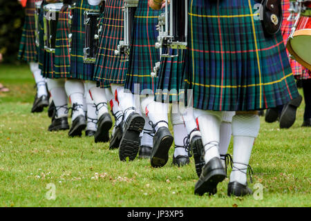 Foto di uomini al di sotto della cintura verde in kilts e calze bianche che stanno marciando in Nuova Zelanda Foto Stock