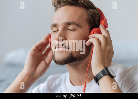 Ritratto di lieto uomo che ascoltare musica Foto Stock