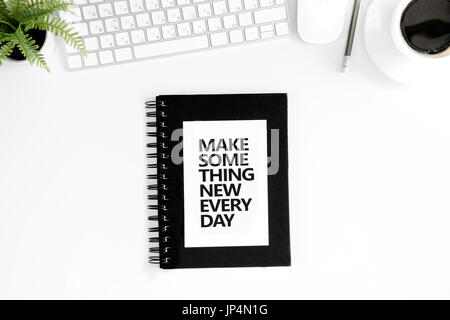 Vista dall'alto di fare qualcosa di nuovo ogni giorno preventivo motivazionale, mouse e tastiera isolato su bianco Foto Stock