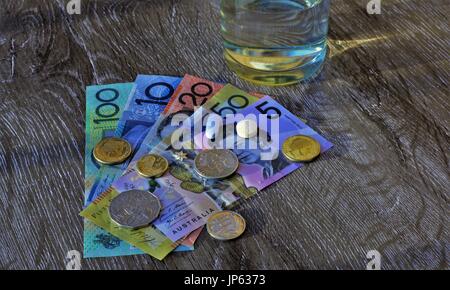 Pillole medicinali in dollari australiani, bicchiere d'acqua. Foto Stock