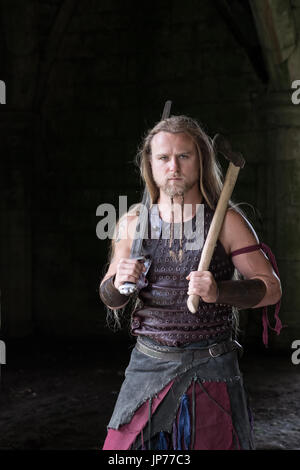 Medieval rievocazione viking warrior soldato, giovane con i capelli lunghi e la barba a treccia e tatuaggio indossando viking Foto Stock