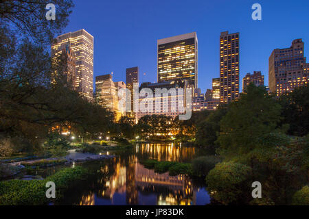 Central Park al crepuscolo con riflessioni di Midtown Manhattan edifici, New York City USA Foto Stock