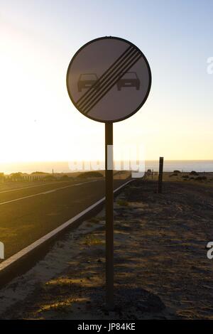 Nessun sorpasso. Vietato indicare in anticipo. In metallo circolare segno del traffico. Ocean road vista. Foto Stock