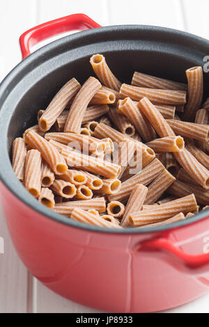 Essiccato rigatoni pasta in pentola. Dark pasta di semola. Paste alimentari non cotte. Foto Stock