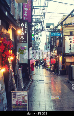 Tokyo, Giappone - Alley con cartelli a Nakano in un giorno arainico Foto Stock