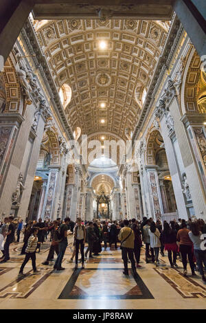 Vista verticale di turisti all'interno della Basilica di San Pietro in Vaticano a Roma. Foto Stock