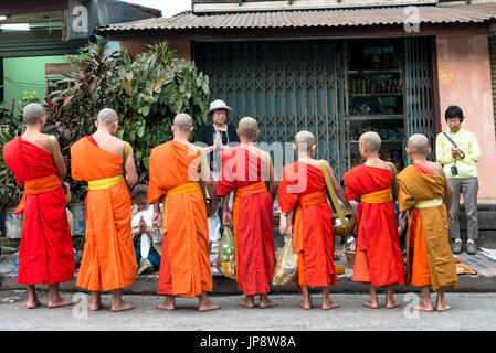 LUANG Prabang, Laos - MARZO 12, 2017: dal retro, i monaci in linea ricevono cibo per il buddista Alms dando cerimonia, a Luang Prabang, Laos. Foto Stock
