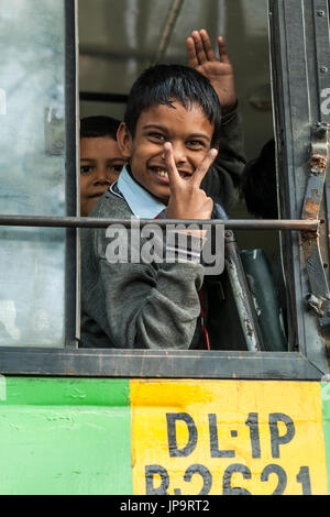 Un ragazzo con la finestra aperta di una scuola bus, Delhi, India. Foto Stock