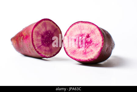 Raw patata viola isolato su sfondo bianco Foto Stock