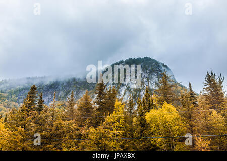 Falesia di montagna dalla highway road con i fili nel tempestoso e nebbioso foggy Meteo montagna regione di Charlevoix del Québec in Canada durante l'autunno Foto Stock