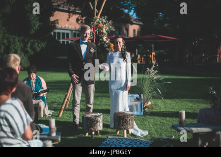 Si alternano sposi a spirituale cerimonia di nozze all'aperto Foto Stock