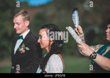 Si alternano sposi al matrimonio spirituale all'aperto cerimonia, cerimonia, piume, metà ritratto Foto Stock