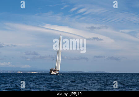 Barche a vela in mare chiaro sotto un cielo di estate blu di Capo Testa a Santa Teresa di Gallura in provincia di Sassari Sardegna Italia Europa Foto Stock
