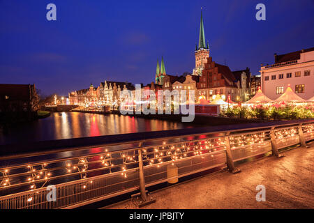 Vista notturna di tipiche case e la cattedrale si riflette nel fiume Trave Lübeck Schleswig Holstein Germania Europa Foto Stock