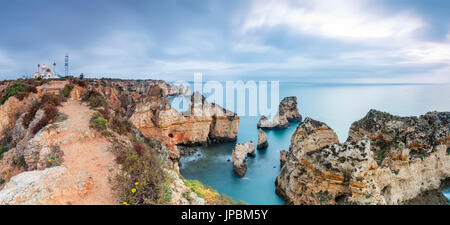 Panorama di scogliere e faro circondata dall'oceano all'alba Ponta Da Piedade Lagos Algarve Portogallo Europa Foto Stock