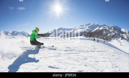 Uno sciatore è lo sci lungo le piste da sci di Folgarida ski resort con Gruppo di Brenta in background, provincia di Trento, Trentino Alto Adige, Italia, Europa Foto Stock