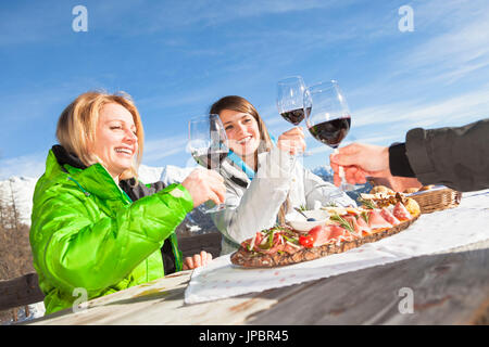 Una snapshot durante una pausa pranzo al di fuori di un rifugio con del buon vino e cucina tipica trentina, provincia di Trento, Trentino Alto Adige, Italia, Europa Foto Stock
