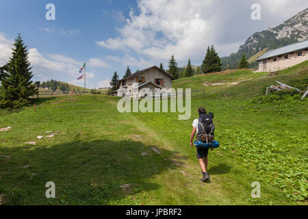 L'Europa, Italia, Veneto, Belluno. Gli escursionisti arrivare al Boz rifugio alpino, sui prati della Neva nel gruppo del Cimonega, Cesiomaggiore, Dolomiti, Belluno Dolomiti Parco Nazionale Foto Stock