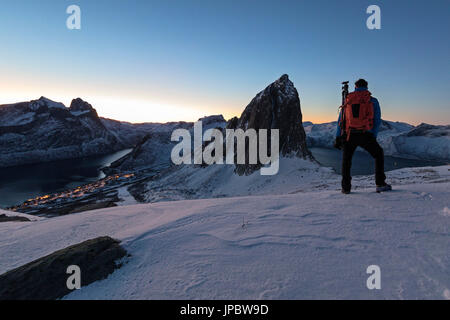 Escursionista si ammira il Monte Segla dal picco Hesten con il villaggio di Fjordgard sulla sinistra e Mefjorden sulla destra Senja Norvegia Europa Foto Stock