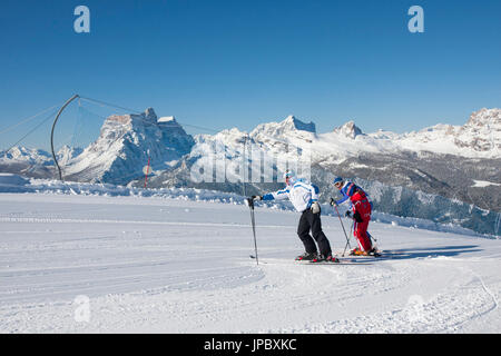 Gli sciatori sulle piste da sci del Monte Faloria con le vette dolomitiche innevate sullo sfondo di Cortina D'Ampezzo dolomiti Veneto Italia Europa Foto Stock