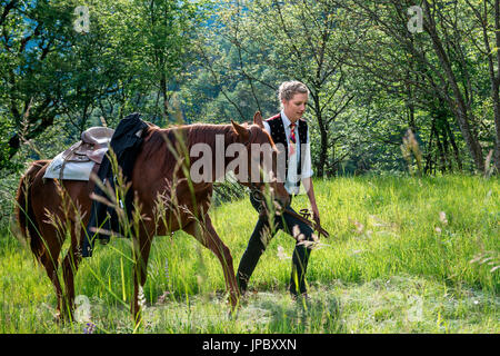 Castelrotto, Alto Adige, Italia. Cavaliere e cavallo sulla strada per il primo torneo Foto Stock