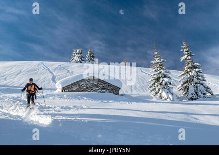 Gli escursionisti con racchette da neve a piedi vicino coperta di neve hut Motta di Olano Gerola Alta Valtellina Alpi Orobie Lombardia Italia Europa Foto Stock