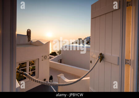 Tramonto sul Mare Egeo visto da una tipica casa greca nel vecchio villaggio di Firostefani Santorini Cyclades Grecia Europa Foto Stock