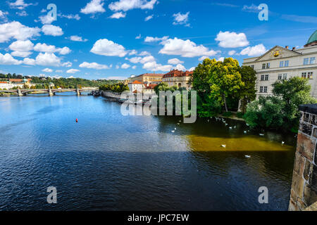 Le rive del fiume Moldava a Praga Repubblica Ceca presi dal Charles Bridge con un altro ponte in background e molti dei cigni Foto Stock