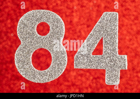 Numero ottantaquattro color argento su di uno sfondo di colore rosso. Anniversario. Posizione orizzontale Foto Stock