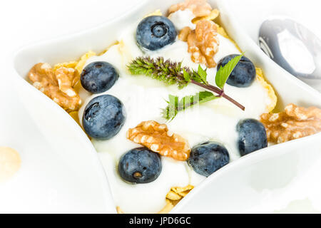 Fiocchi di mais con yogurt, miele, noci e mirtilli. concetto di alimenti sani. Foto Stock