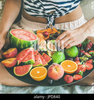 Ragazza giovane con la frutta sana colazione a letto, quadrato ritaglia Foto Stock