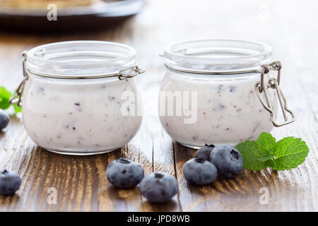 Organico sano mirtillo frullati con frutti di bosco freschi in vasetti di vetro su tavola in legno rustico Foto Stock